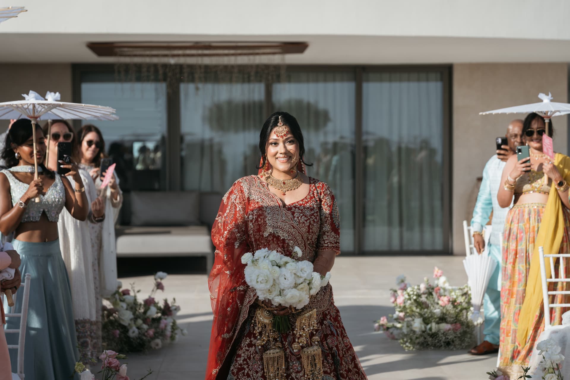 Cynthia walking toward the ceremony carrying white flowers