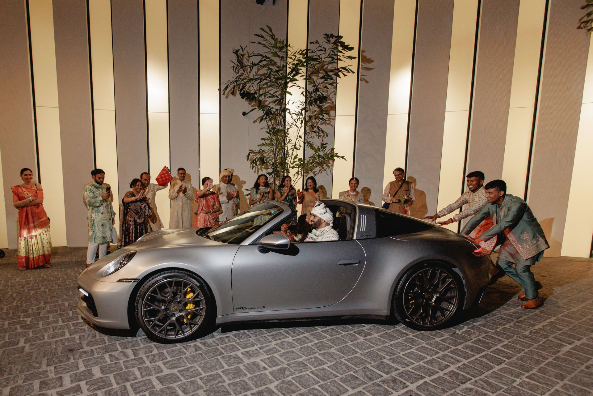 Shivam departing the ceremony in a silver convertible surrounded by loved ones