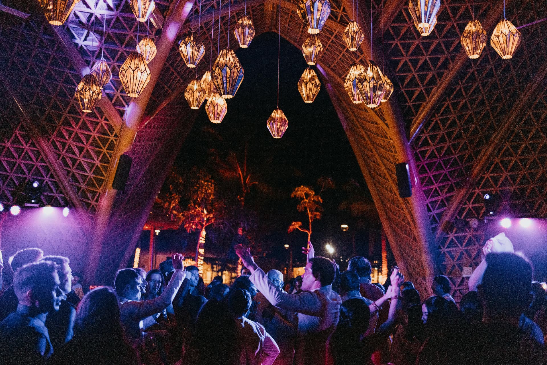 Evening celebration beneath purple and amber hanging lanterns