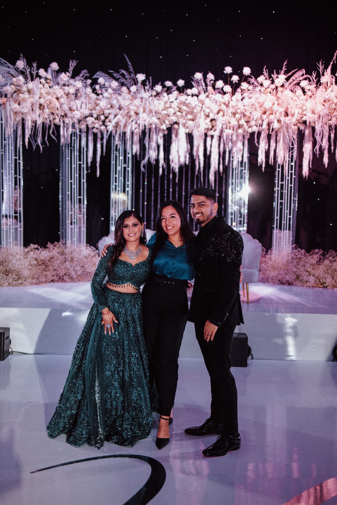 Guests photographed at night in front of the pink floral installation