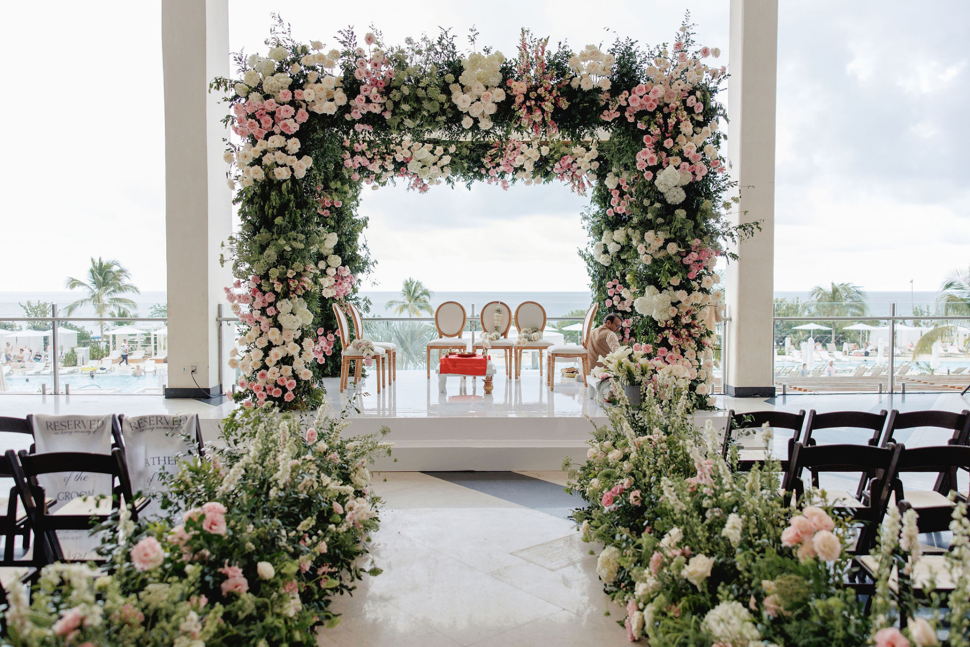 An oceanfront ceremony aisle framed by flowers