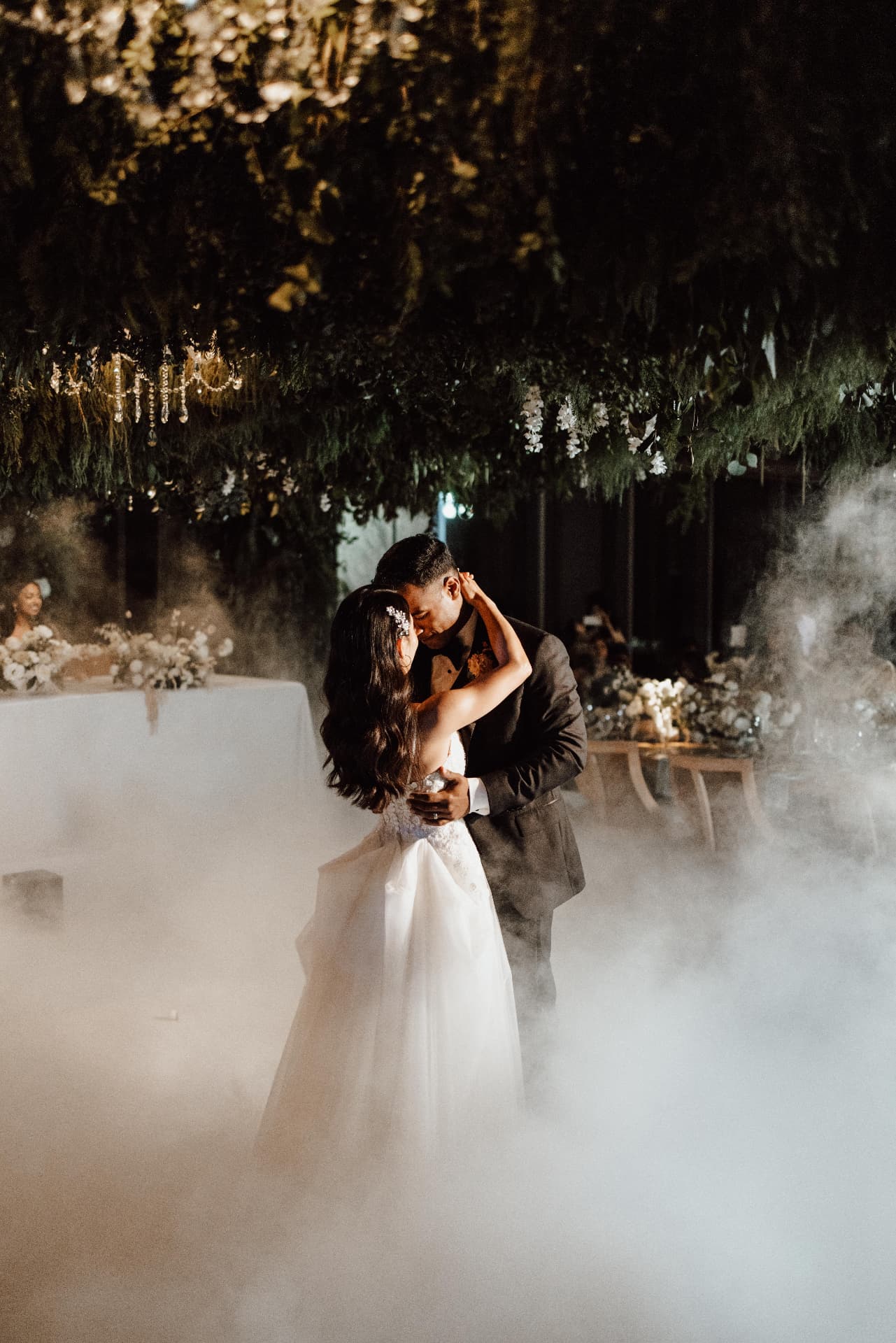 Couple portrait at night surrounded by greenery and fog
