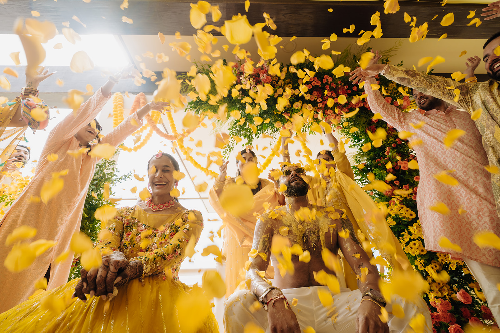 Sneha and Apoorv celebrating beneath falling flower petals