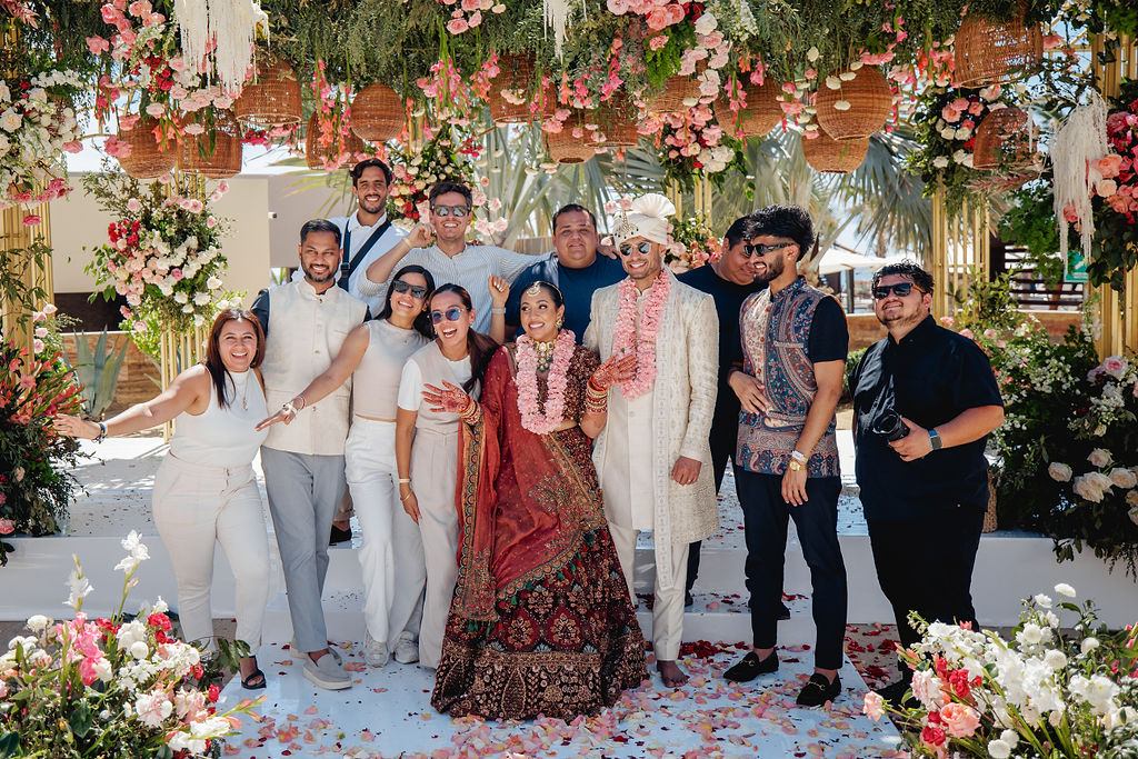 Group portrait beneath dense floral and woven décor