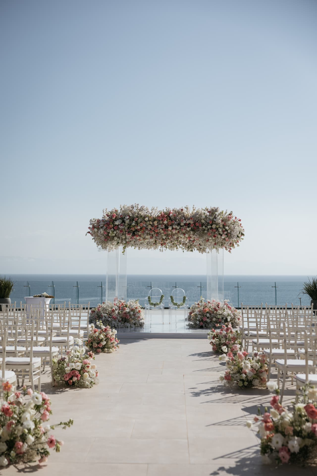 Oceanfront ceremony setting with a suspended floral canopy