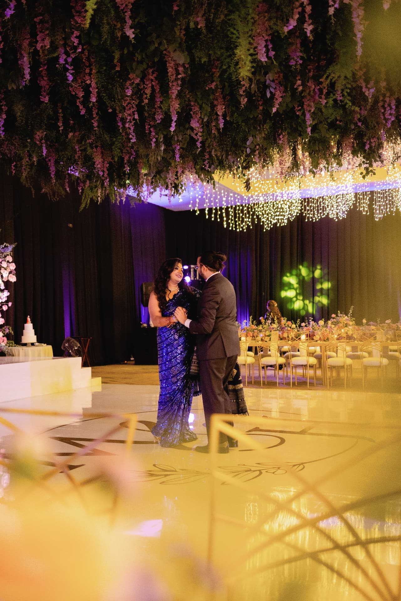 First dance beneath hanging flowers and lights