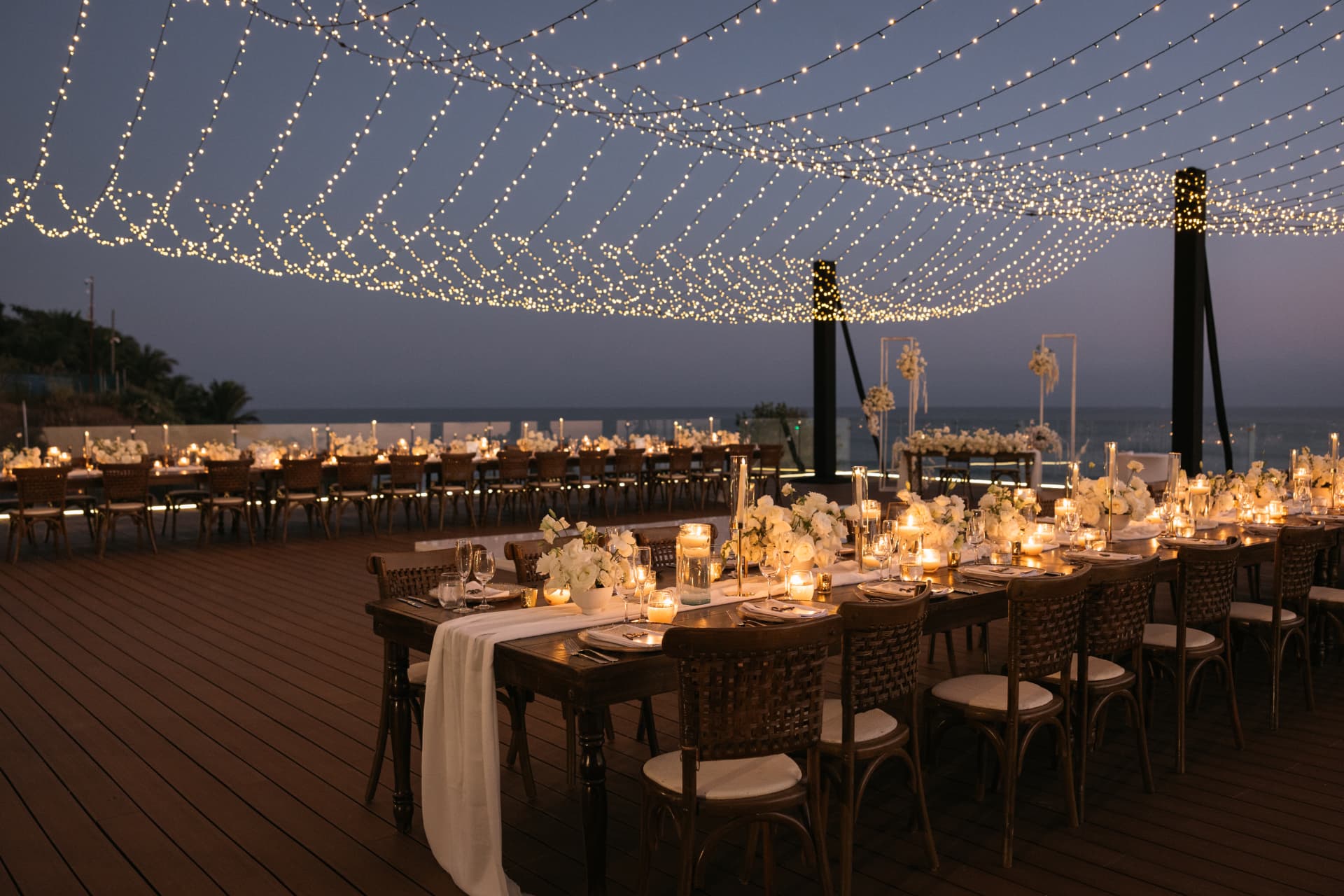 Candlelit reception tables beneath a canopy of string lights
