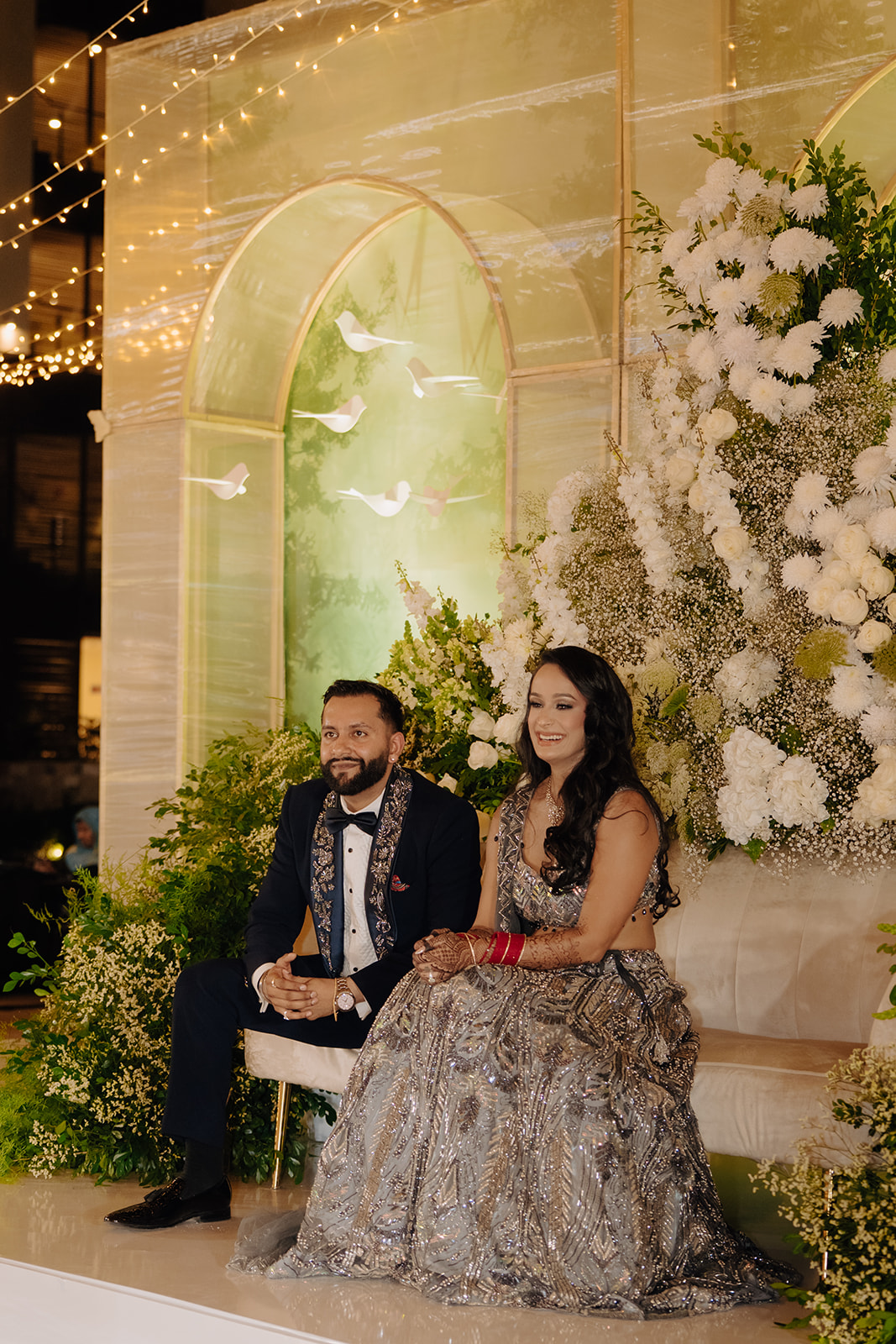 Sneha and Apoorv in an evening portrait before white flowers