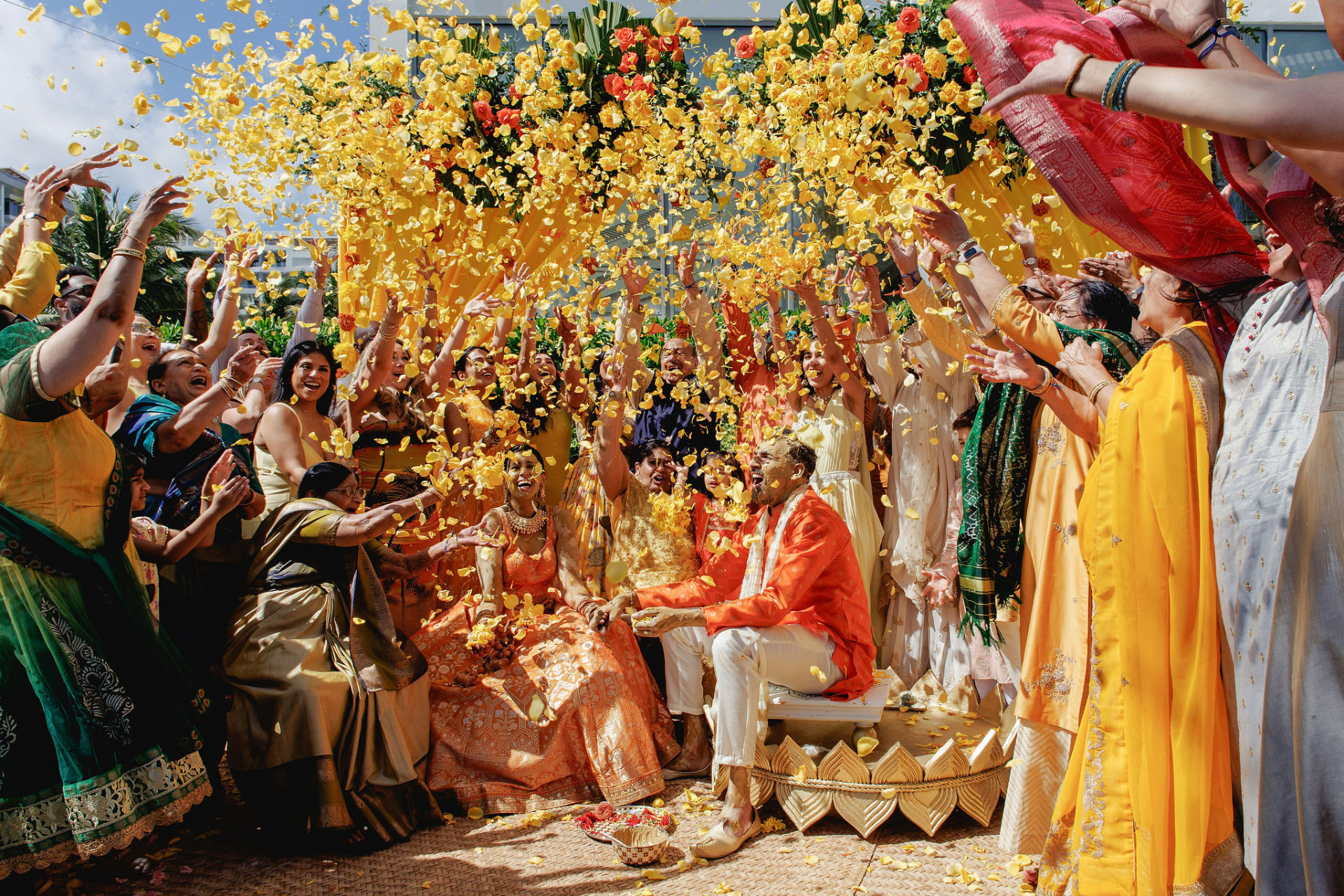 Guests celebrating the Haldi, yellow petals in the air