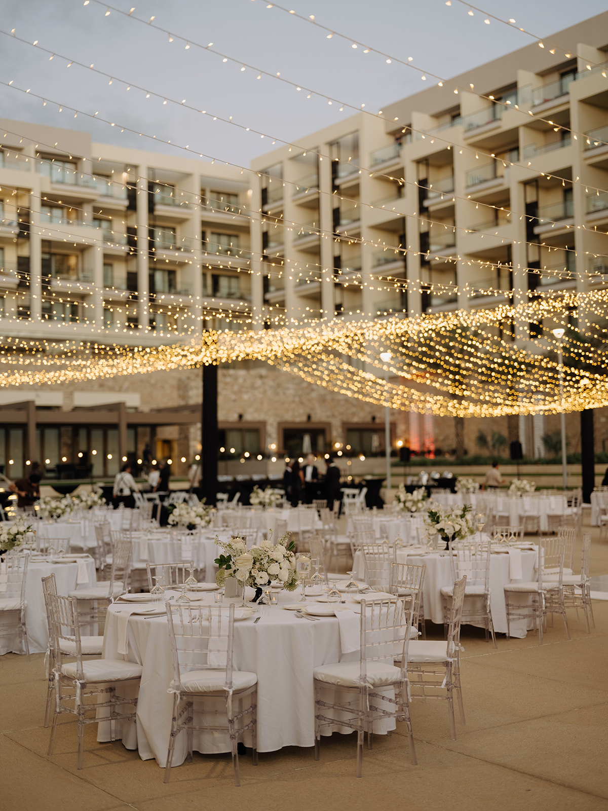 An outdoor reception beneath strings of lights