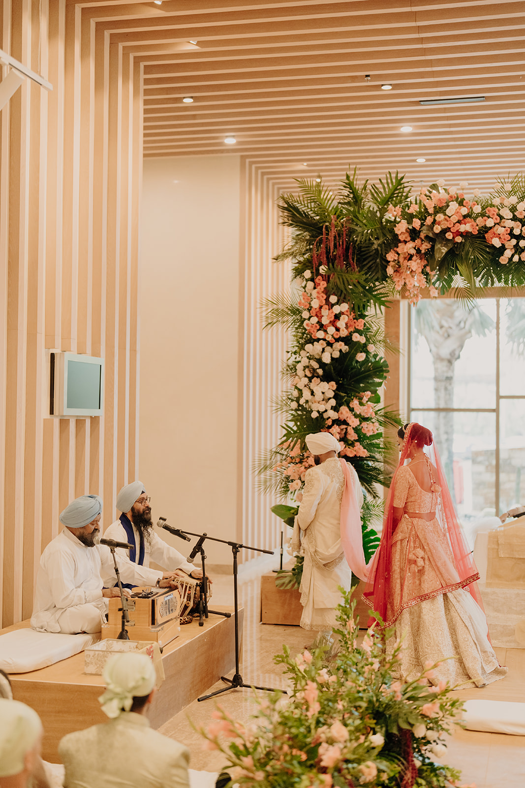 A ceremony procession beneath the floral arch