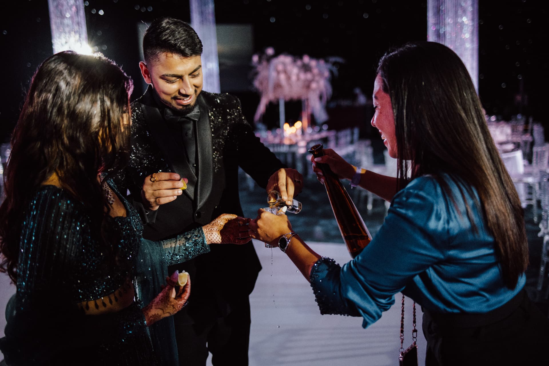 Guests pouring a drink for the groom late in the evening
